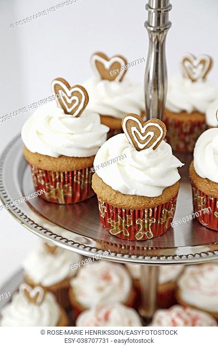 Cupcakes decorated with gingebread hearts in a two tier stand
