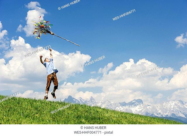 Austria, Salzburg State, Altenmarkt-Zauchensee, teenager throwing Palmbusch up in the air