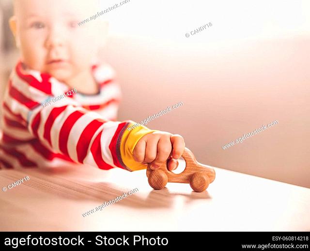 Little boy playing with wood car indoor. Concept of family travel