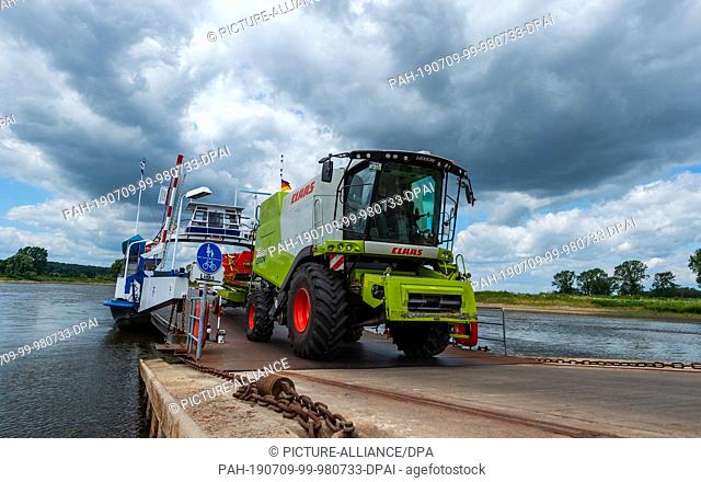 01 July 2019, Lower Saxony, Neu Darchau: A combine harvester leaves the Elbe ferry ""Tanja"". It's only a few hundred meters