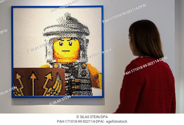 A woman looking at a mosaic made of legos as part of the special exhibition called ""cities-castles-pyramids"" is showing, a.o