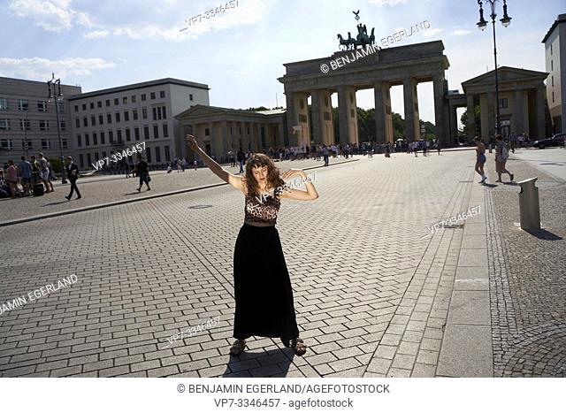young sensual woman dancing in front of Brandenburg Gate, Brandenburger Tor, in Berlin, Germany