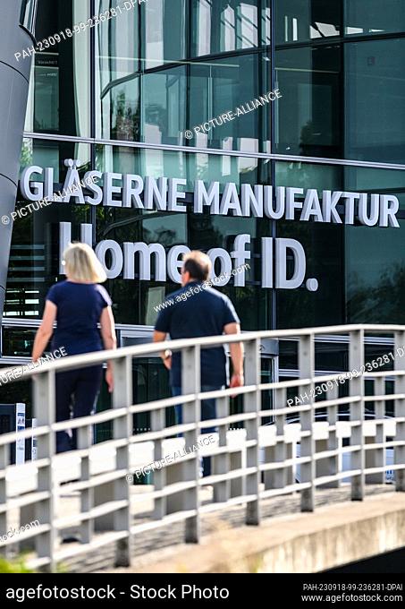 18 September 2023, Saxony, Dresden: A woman and a man walk along in front of the entrance to the Transparent VW Factory. According to a report in...