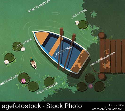 Rowboat and paddles on tranquil lake with lily pads