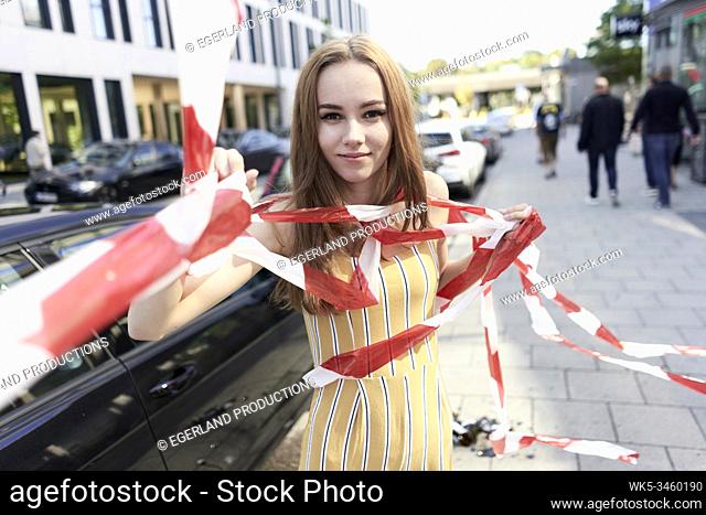 confident woman tangled in caution tape. Munich, Germany