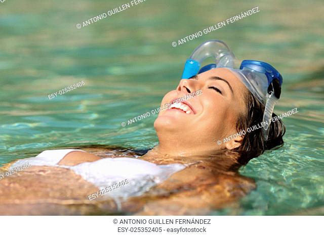 Tourist woman bathing on a tropical beach on summer holidays floating on a turquoise water