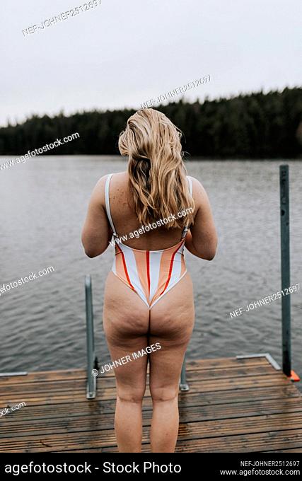 Rear view of woman standing at jetty