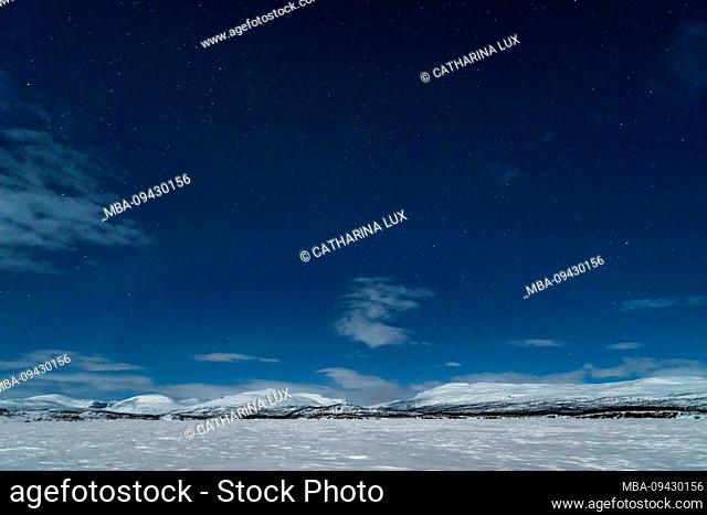 Sweden, Lapland, Abisko, frozen lake (Torneträsk) in the moonlight, night sky