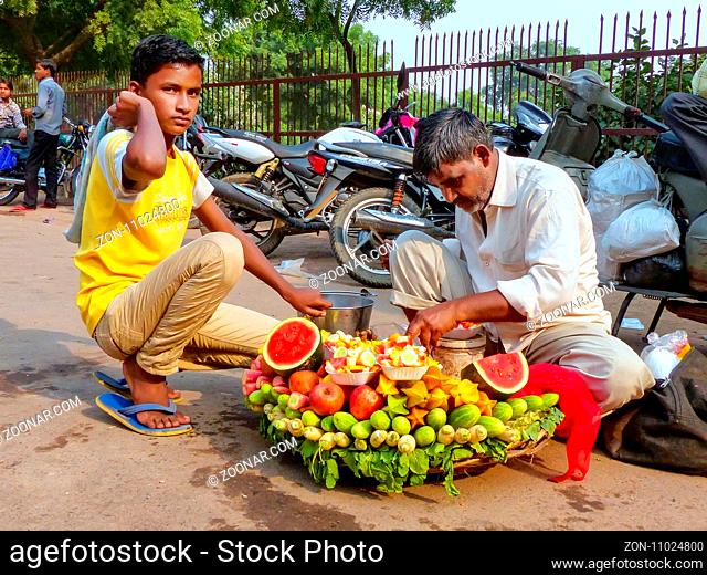 Local man with a boy selling fruit outside Jama Masjid in Fatehpur Sikri, Uttar Pradesh, India. The city was founded in 1569 by the Mughal Emperor Akbar