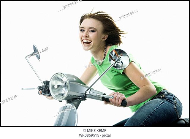Portrait of a teenage girl riding a scooter