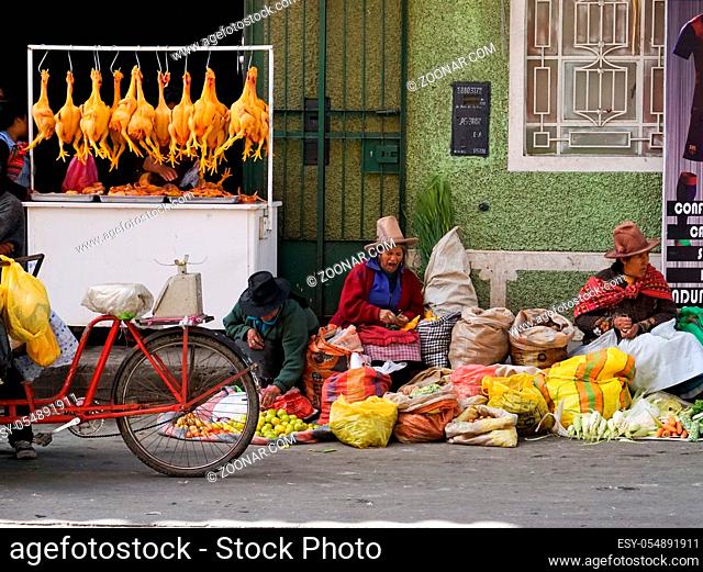 Huaraz, Ancash / Peru: 11 June 2016: horizontal view of indigent Indio farmer women sell their fruit and vegetables on the streets of Huaraz