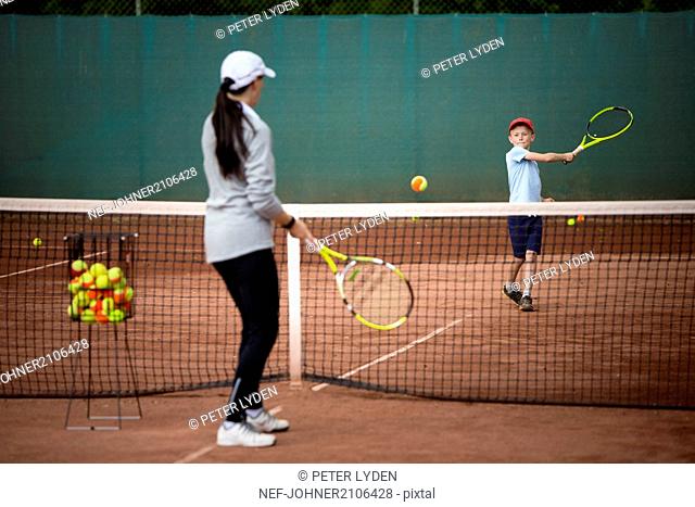 Mother with son playing tennis