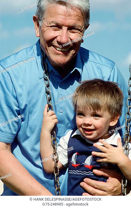 Young boy on swing with grandfather