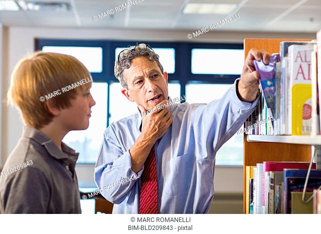 Teacher and student working in library