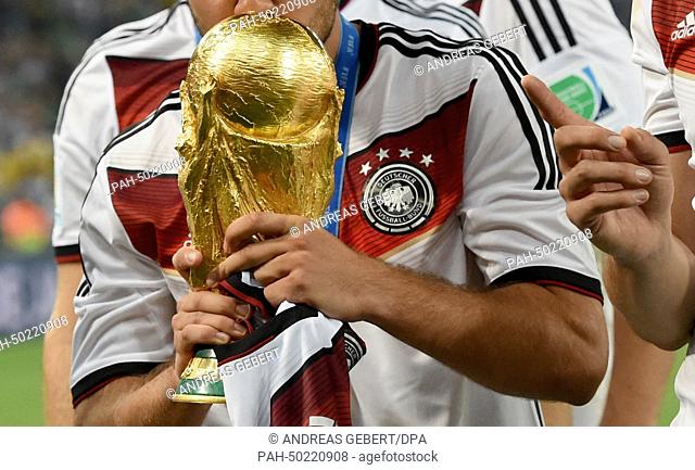 Mario Goetze of Germany kisses the World Cup trophy after winning the FIFA World Cup 2014 final soccer match between Germany and Argentina at the Estadio do...