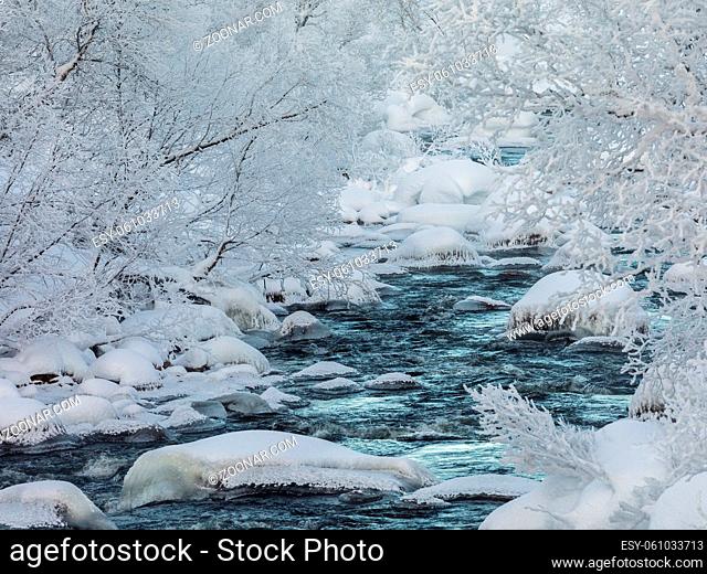winter creek, streaming water with snow and ice, river surrounded with snow covered trees