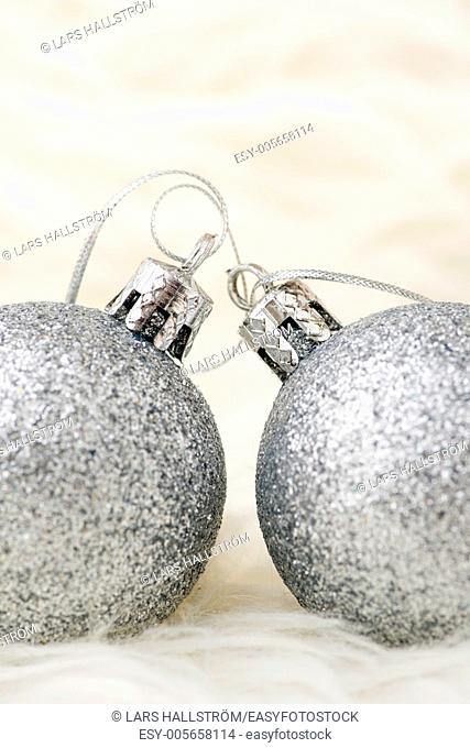 Two sparkling silver colored christmas baubles