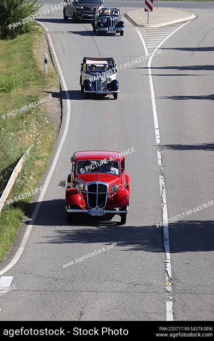 17 July 2022, Saxony, Reinsdorf: A Hansa Borgward 1100, built in 1936, and other vintage cars drive along a road during the 10th vintage car drive ""August...