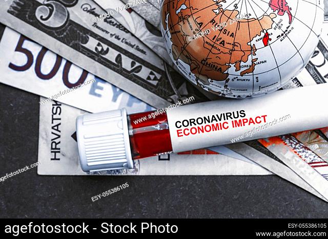 CORONAVIRUS ECONOMIC IMPACT text with currency banknotes, world globe and blood test vacuum tube on black background. Covid-19 or Coronavirus Concept