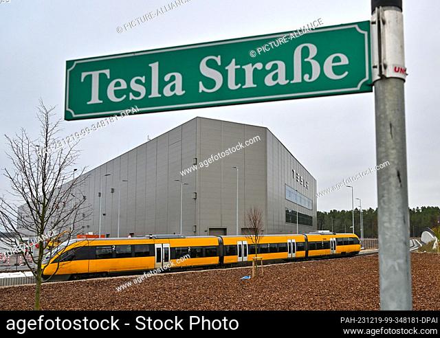 PRODUCTION - 18 December 2023, Brandenburg, Grünheide: A train travels to the Tesla Gigafactory Berlin-Brandenburg. The plant of the planned battery factory can...