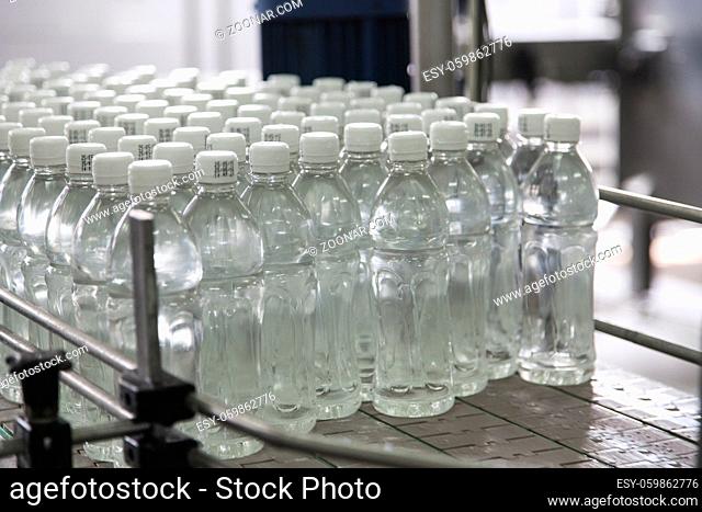 Bottle filled with water standing on the assembly line