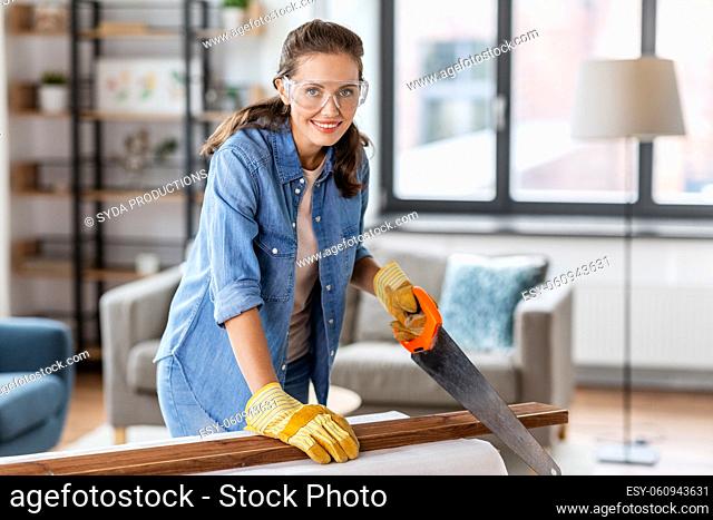 woman with saw sawing wooden board at home