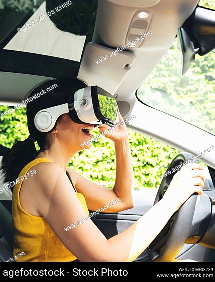 Woman wearing virtual reality simulator while driving electric car