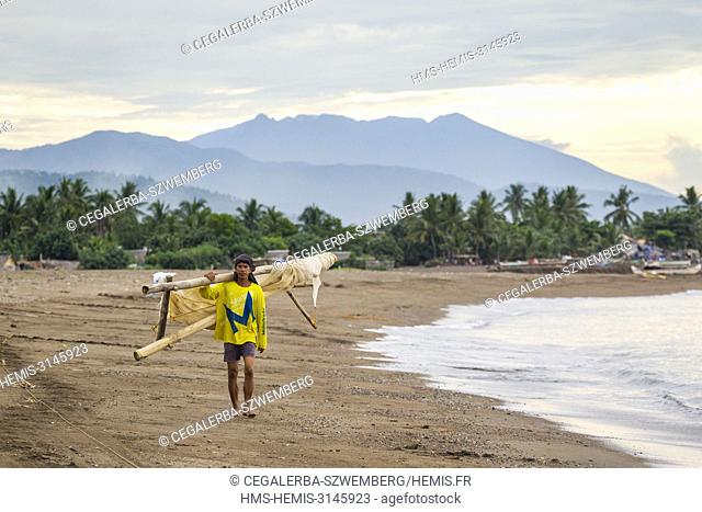 Philippines, Luzon, Albay Province, Tiwi, wild-caught fry fisherman walking on the beach