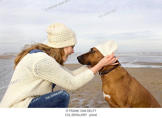 Portrait of mid adult woman and dog on beach, Bloemendaal aan Zee, Netherlands