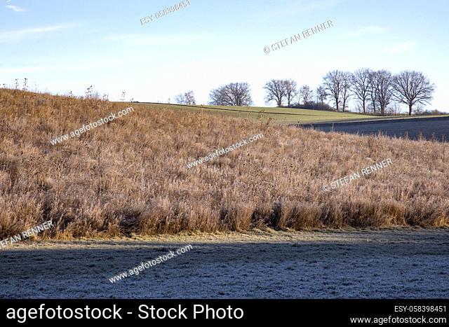 Barren fallow field with brown stubble in winter at cold temperatures in Bavaria