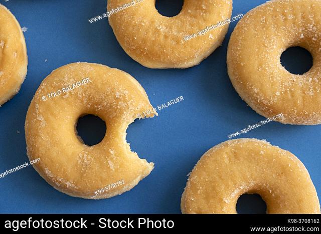 Bitten donut on blue background
