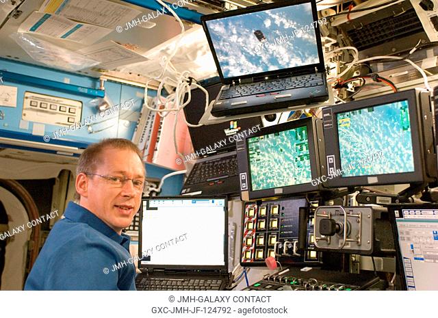 At the Canadarm2 work station in the Destiny laboratory, European Space Agency astronaut Frank De Winne monitors the unpiloted Japanese H-II Transfer Vehicle...