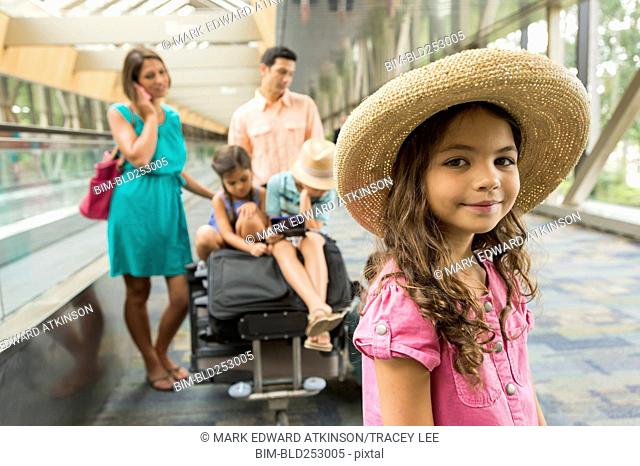 Portrait of girl waiting in airport with family