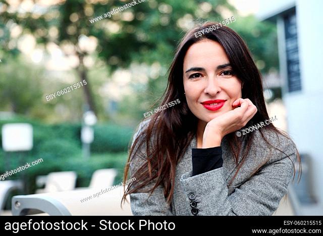 Portrait of business woman smiling outdoor, wearing grey suit. High quality photo