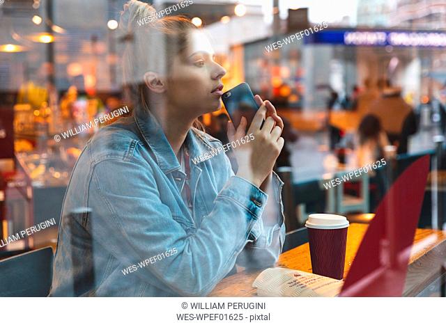 Young woman with smartphone in a cafe