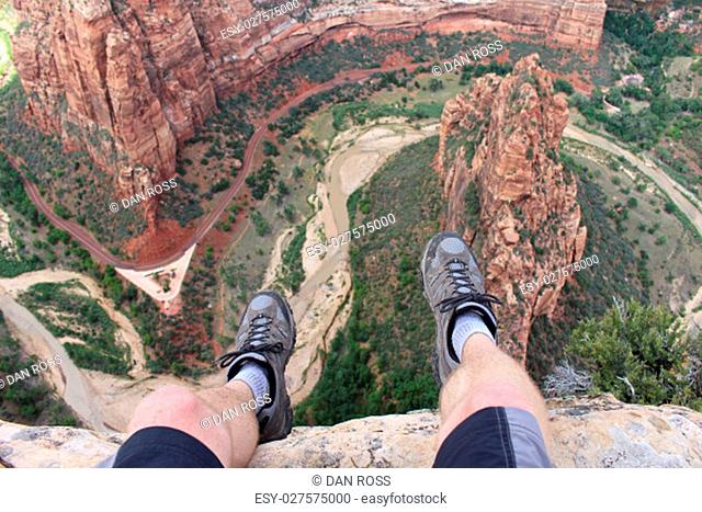 First person perspective shot from a hiker sitting at the edge of a cliff at Angel's Landing in Zion National Park