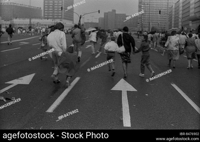 GDR, Berlin, 01. 05. 1987, 1. May rally 1987 on Karl-Marx-Allee, rain showers, participants running towards Alex (Alexanderplatz)