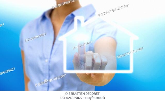 Bussinesswoman drawing a house with her finger on a tactile screen