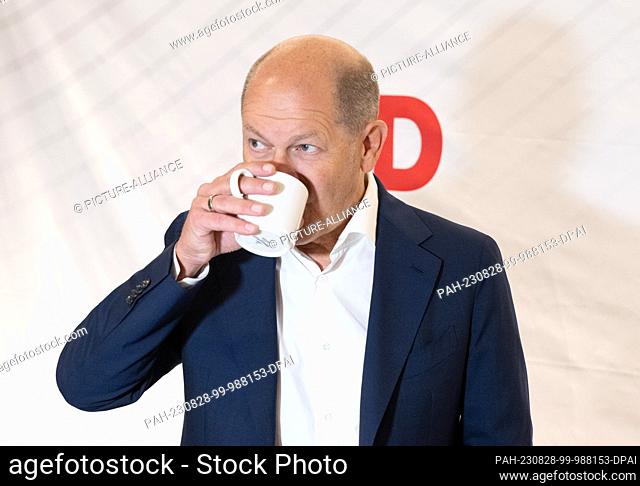 28 August 2023, Hesse, Wiesbaden: Chancellor Olaf Scholz (SPD) arrives at the closed meeting of the SPD parliamentary group in Wiesbaden with a coffee cup in...