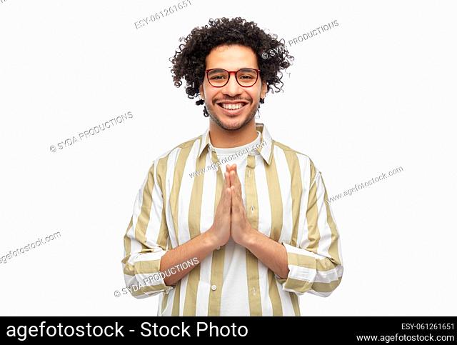 happy man in glasses making namaste gesture