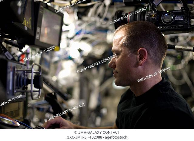 Inside the International Space Station's Cupola, Expedition 34 Flight Engineer Tom Marshburn assists fellow crew members (out of frame) during capture and...