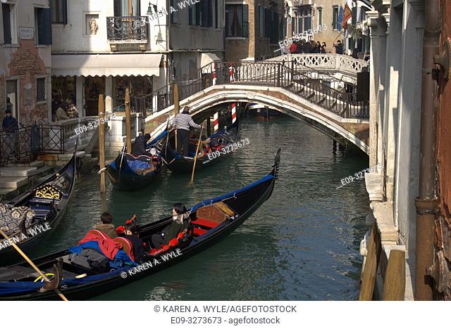 canal with three gondolas and two bridges, Venice, Italy