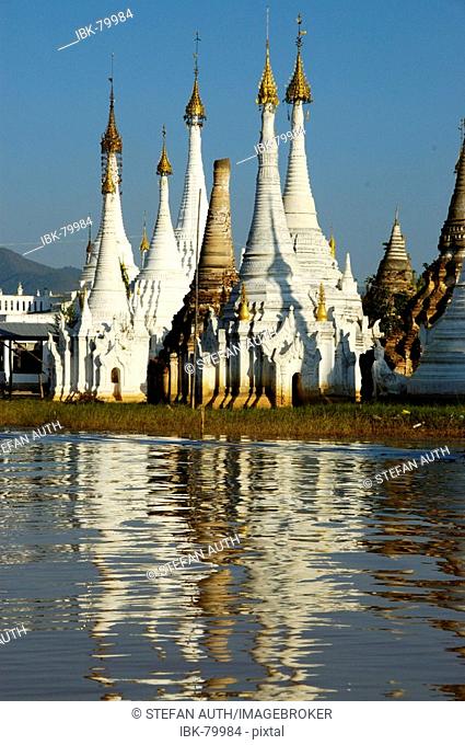 Slim stupas of Aung Min Ga Lar Paya reflect in the water Inle Lake Shan State Burma