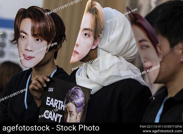 10 November 2022, Egypt, Sharm El-Sheikh: Climate activists of the BTS Army, wearing faces of members of the BTS South Korean boy band