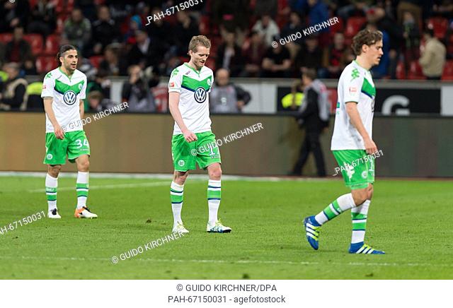 Wolfsburg's Ricardo Rodriguez, Andre Schuerrle and Max Kruse (L-R) leave the field after the 3-0 defeat at the German Bundesliga soccer match between Bayer...