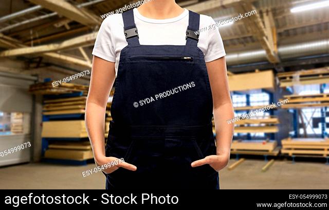 close up of female worker in overall at factory