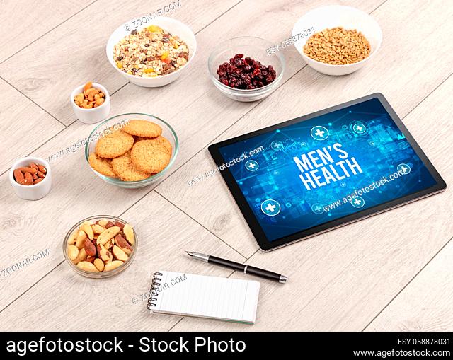 MEN?S HEALTH concept in tablet pc with healthy food around, top view