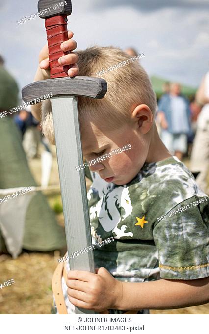 Boy holding wooden sword