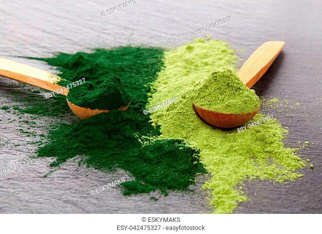 Adaptogen background. Ground powdered chlorella and barley top view. Superfood concept