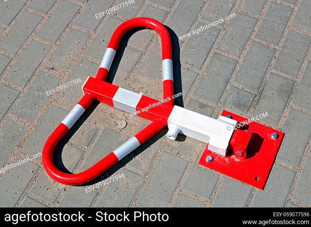 Metal red stopper lock in private car parking made from steel pipes